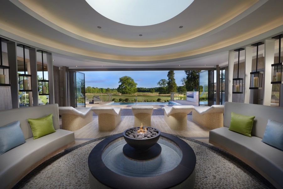 An outdoor infinity pool next to a row of spa chairs